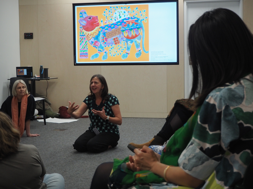 Person kneeling on the floor while presenting to a group